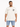 A man stands wearing a loose-fitting beige t-shirt and light blue denim shorts with a cuffed hem.