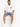 A man sits on a white cube wearing denim shorts and a light-colored oversized t-shirt with graphic text.
