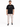 A man stands wearing a black t-shirt with white text, paired with light cargo pants and black sneakers.