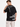 A man wearing a black t-shirt with white text and graphic designs on the back, showcasing motivational phrases.