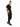 A man poses in a black t-shirt and matching joggers, showcasing a stylish, casual look with sneakers.
