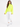 A woman walks confidently in a bright neon green turtleneck top paired with white joggers and sneakers.
