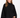 A woman with long hair wears a black, oversized sweatshirt with a high neckline and wide sleeves.