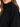 Close-up of a woman wearing a black sweatshirt with a high collar and relaxed fit, showcasing soft fabric texture.