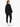A woman stands with her back to the camera, wearing a black oversized sweatshirt and matching joggers with white snea...
