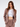 A model poses in a fitted, light brown blazer and matching trousers over a white crop top, showcasing a stylish look.