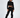 A model poses in a cropped black sweatshirt and matching jogger pants, showcasing a casual streetwear style.