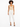A model wearing a fitted beige bodysuit paired with tailored white pants and black strappy heels.