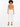 A model wearing a fitted, tan bodysuit paired with tailored white pants and black strappy heels.