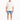 A man stands wearing a loose-fitting white t-shirt and distressed denim shorts, paired with white sneakers.