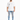 A man stands wearing a loose white t-shirt and distressed light blue jeans with multiple rips, paired with white snea...