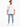 A man stands wearing a loose white t-shirt and distressed light blue jeans with multiple rips, paired with white snea...