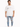 A man stands wearing a loose white graphic t-shirt and light blue ripped jeans, showcasing a casual style.