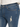 Close-up of blue denim jeans featuring a distressed patch and classic five-pocket design with contrasting stitching.