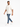 A man walks confidently in distressed blue jeans paired with a light beige oversized t-shirt and white sneakers.