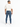 A man wearing a loose-fitting cream t-shirt and fitted blue jeans, viewed from the back, with white sneakers.