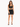 A model poses in a black crop top with lace-up details and a matching skirt featuring side ties.