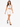 A model walks confidently in a white lace-up crop top and matching skirt with side ties and black heels.