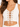 A close-up of a woman wearing a white cropped top with a lace-up front and gold eyelets, showcasing a casual style.