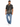 A man stands wearing a short-sleeve black shirt with a cream abstract pattern, paired with light blue jeans and white...