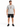 A man stands wearing a light gray t-shirt with a colorful graphic design, paired with black shorts and sneakers.