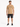 A man stands wearing a tan t-shirt with a graphic design, paired with black denim shorts and sneakers.