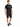 A man stands wearing a black t-shirt with a graphic design, paired with distressed black shorts and sneakers.