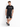 A man stands casually in a black t-shirt, paired with dark shorts and stylish sneakers, against a white background.