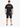 A person wearing a black t-shirt with a graphic design on the back, paired with dark denim shorts and sneakers.