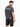 A man wearing a gray t-shirt with a graphic design on the back, paired with black denim shorts.