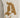 Beige apparel featuring a textured, brown logo design on the thigh, adding a unique visual element.