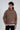 A young man wearing a brown hoodie with motivational text, featuring a front pocket and relaxed fit.