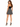 A woman stands in a fitted black top and a flared black and white patterned skirt, showcasing stylish high heels.
