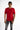 A model wearing a fitted red t-shirt with black text and distressed gray jeans, posing against a white background.