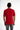 A person wearing a red short-sleeve shirt with contrasting text on the cuffs and hem, viewed from the back.