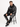 A man sits on a stool wearing a black hoodie and matching sweatpants with a coral-inspired design.