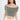 A model poses in a soft, off-the-shoulder, cropped top in a muted green shade, paired with a white skirt.