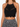 Black crochet halter top featuring intricate patterns and a scalloped hem, paired with a patterned skirt.