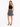 A woman poses in a black crochet crop top and a flared black and white leopard print skirt, paired with strappy heels.
