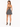 A woman stands in a black halter top with a patterned skirt, showcasing a stylish back design and high heels.