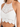 Crochet halter top featuring intricate patterns and a scalloped hem, perfect for warm weather styling.