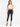 A model poses in a white crochet crop top and black skinny jeans, showcasing a stylish summer outfit.