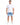 A man stands confidently in a fitted white short-sleeve shirt paired with light denim shorts and white sneakers.