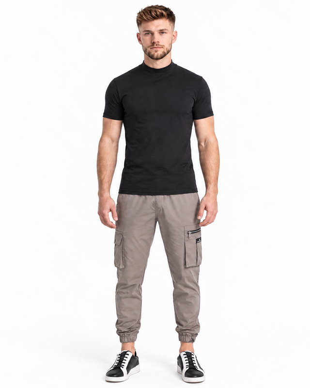 A man stands confidently wearing a fitted black t-shirt paired with light gray cargo pants and black sneakers.