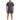 A man stands confidently in a navy blue short-sleeve top paired with matching shorts and white sneakers.