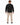 A person wearing a textured black sweatshirt stands with their back to the camera, paired with beige pants and black...