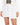 Nina Skirt Set in White – close-up of the asymmetric overlap mini skirt worn with cropped blazer