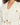 Rhea Jacket in Cream – close-up of notched lapels, flap pockets, wooden-look buttons and rope drawstring waist