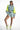 Alexia light blue and neon yellow cropped windbreaker top with matching high-waisted shorts and white platform sneakers.