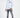 Man in white HEARTBIT long-sleeve graphic shirt and distressed gray jeans against a white studio background.